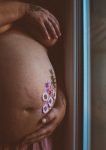 photo de grossesse avec petites fleurs sur le ventre